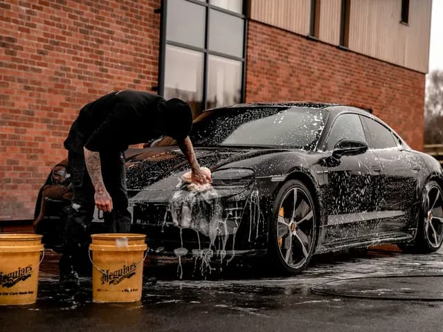 Water splashing on a car's hood during a detailing job