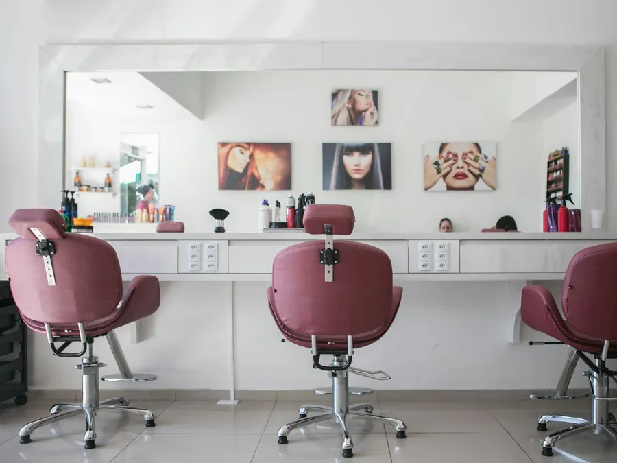 Salon chairs facing a long mirror